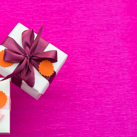 A set of gifts Packed in beautiful boxes. White box on a pink background. Flat lay top viewの写真素材