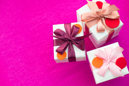 A set of gifts Packed in beautiful boxes. White box on a pink background. Flat lay top viewの写真素材