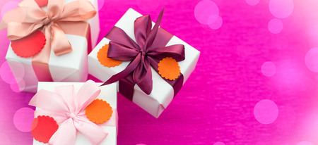 Banner A set of gifts Packed in beautiful boxes. White box on a pink background. Flat lay top viewの写真素材