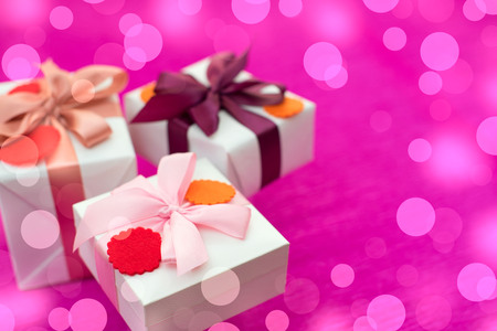 A set of gifts Packed in beautiful boxes. White box on a pink background. Flat lay top viewの写真素材