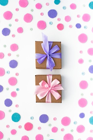 Two Gift boxes on festive background of pastel confetti. Flat top viewの写真素材
