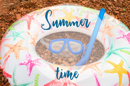 Beach accessories on the sea pebble. Lifeline Underwater mask Tube Sandals. Flat lay top view