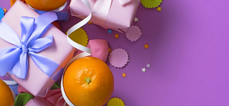 Banner Decorative composition Two boxes with gifts Satin ribbon Bow Oranges Confetti Serpentine birthday party. The view from the topの写真素材