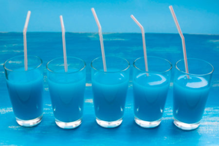 defocused glass glasses with blue cocktail drink candy color blue saturation festive background