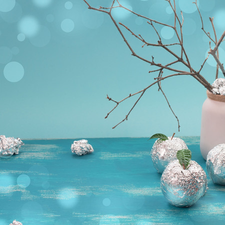 Apple tree wrapped in foil is a natural green leaves. Wooden candy blue background. Flat flat top viewの写真素材