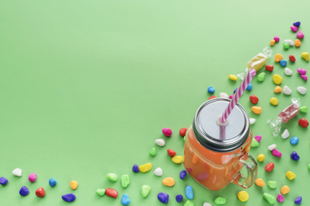 Natural Fresh Smoothies Drink in glass Cup with straw on green background. Candy colored sweets. Flat lay top viewの写真素材