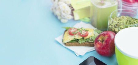 Banner Healthy vegetarian Breakfast Sandwich grain bread tofu cheese, detox smoothie, pumpkin seeds, cherry tomatoes, natural flowers, blue background, notebook, Lunch box soup for lunch.の写真素材
