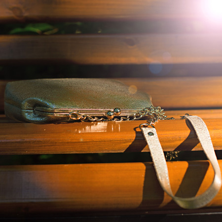 Beautiful bag for women, lying on a wooden bench. A warm summer eveningの写真素材