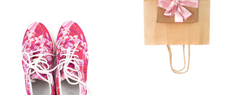 Women's fashion sneakers pink on a white background. Paper bag for shopping. Flat top viewの写真素材