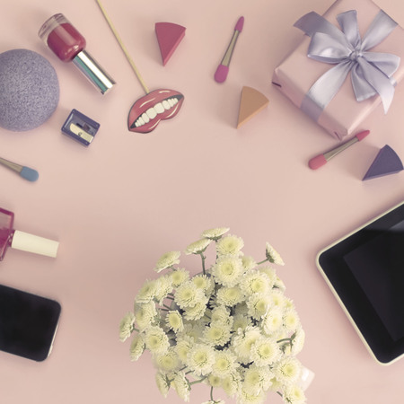 Bouquet of chrysanthemum, cosmetics, accessories, phone, gift and tablet on pink background.の写真素材