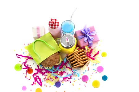 Festive composition of drinks, snacks, holiday hamburger, cookie, tinsel, confetti, gift box, cocktail and saturated colors. Children's holiday birthday partyの写真素材