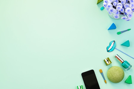 Bouquet of chrysanthemums, cosmetics, accessories and phone on green background. Top view copy space flat layの写真素材