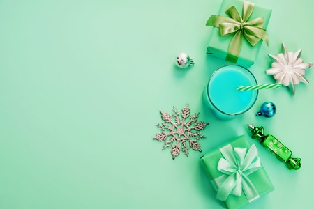 Christmas composition flat lay boxes with gifts satin ribbon bow, Christmas toys and snowflakes. Decorative frame top view green backgroundの写真素材