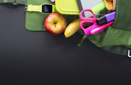 Backpack with school supplies on black background. Top view flat layの写真素材