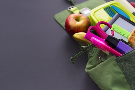 Backpack with school supplies on black background. Top view flat layの写真素材