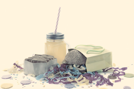 Festive composition of drinks, snacks, holiday hamburger, cookie, tinsel, confetti, gift box, cocktail and saturated colors. Children's holiday birthday partyの写真素材