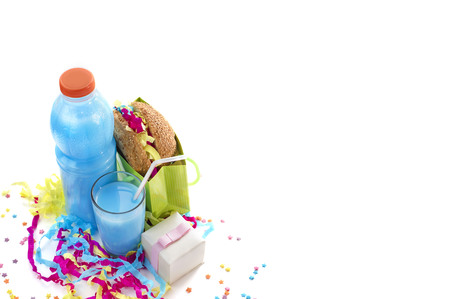 Festive composition of drinks, snacks, holiday hamburger, cookie, tinsel, confetti, gift box, cocktail and saturated colors. Children's holiday birthday partyの写真素材
