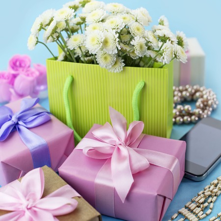Decorative composition boxes with gifts flowers women's jewelry shopping holiday blue background. Festive poster square.の写真素材