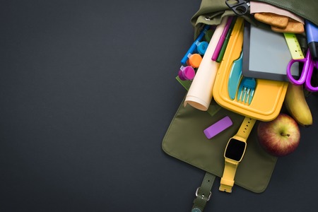 Backpack with school supplies on black background. Top view Flat layの写真素材