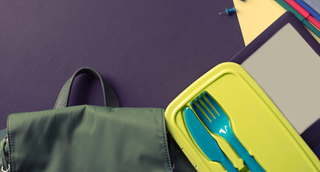Concept back to school watch banana lunchbox stationery on black background.