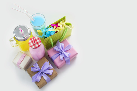 Decorative composition festive exotic cocktail on white background box with confetti gift satin ribbon. Natural drink in a glass mugの写真素材