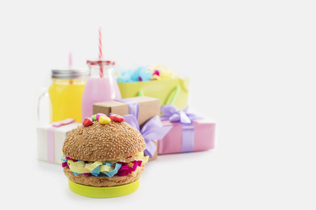 Festive composition drinks snacks holiday hamburger cookie tinsel confetti gift box cocktail cactus saturated colors. Children's holiday birthday partyの写真素材