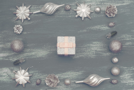 Festive composition flat lay Christmas toy balls cones snowflakes silver box wooden vintage background. Top view copy spaceの写真素材