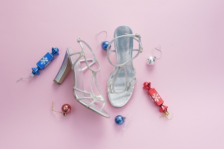 Decorative background pink Christmas composition Flat lay box gift ribbon bow snowflake sandals silver Christmas tree toys. Top view copy spaceの写真素材