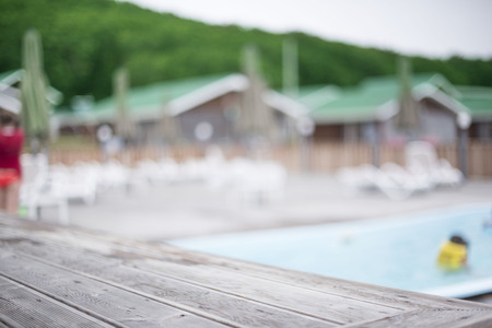 Defocus blurred background recreation base wooden houses pool sunbeds wooden floor hill forest trees sky toning. Recreation center for outdoor relaxationの写真素材