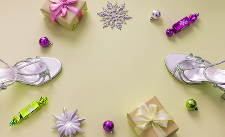 Decorative background yellow Christmas composition Flat lay box gift ribbon bow snowflake sandals silver Christmas tree toys.の写真素材