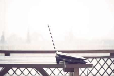 Wooden table on the veranda office laptop Internet modern gadget copy space. Lifestyle to the countryside work spaceの写真素材