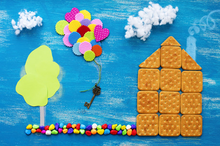 The concept of a cookie house on a wooden blue sky cloud background family path. Top view Flat layの写真素材