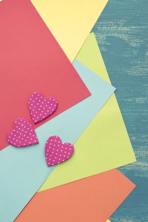 Colored sheets of paper on a wooden painted blue background decorative heart Valentine's day. Graphic design copy spaceの写真素材