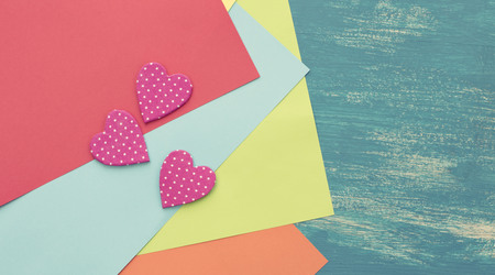 Colored sheets of paper on a wooden painted blue background decorative heart Valentine's day. Graphic design copy spaceの写真素材