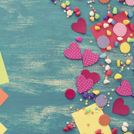 Festive confetti background heart candy color saturated. Wood old blue background with copy space flat layの写真素材