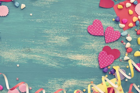 Festive confetti background heart candy color saturated. Wood old blue background with copy space flat layの写真素材