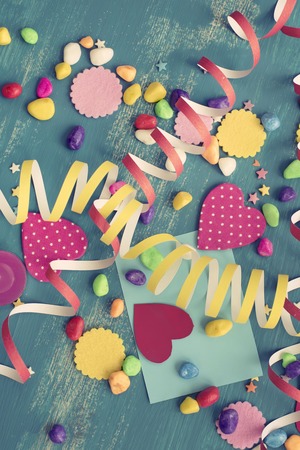 Festive confetti background heart candy color saturated. Wood old blue background with copy space flat layの写真素材