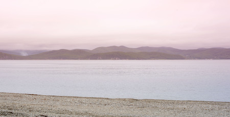 Banner seascape morning dawn horizon sea coast Bay hill sea pebble. Natural background sea beach copy spaceの写真素材