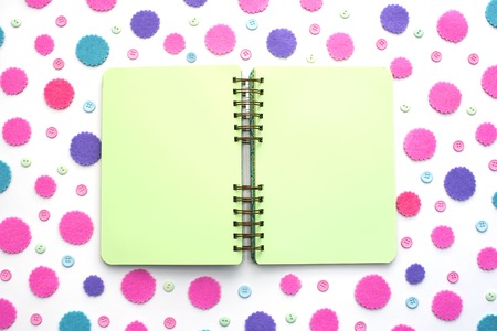 Open Notepad green pages on colored confetti background. Top view flat layの写真素材