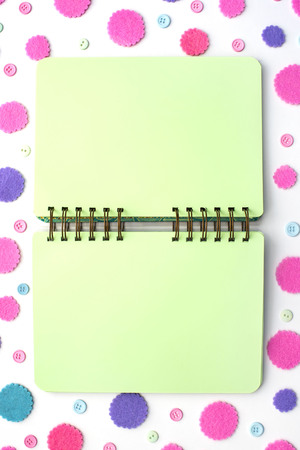 Open Notepad green pages on colored confetti background. Top view flat layの写真素材