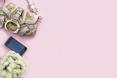 Modern fashion accessories young women shoes handbag phone gadget lipstick cosmetics bouquet flowers pink background. Top view flat layの写真素材