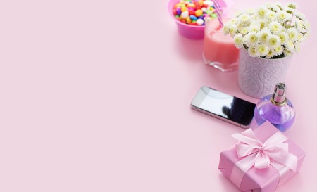 Composition flat lay gift to a woman Modern gadget mobile phone glass cocktail perfume bouquet of flowers Preparing for the holiday surprise gift box pink backgroundの写真素材