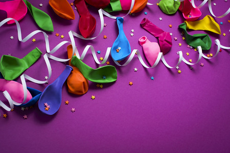 Festive background of purple material colorful balloons streamers confetti Top view flat lay copy spaceの写真素材