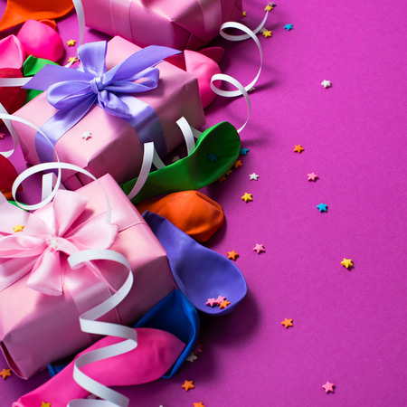 Festive background of purple material colorful balloons streamers confetti box gift Top view flat lay copy spaceの写真素材