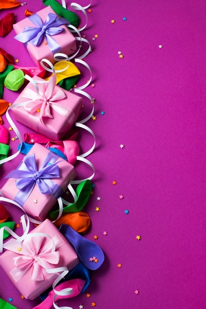 Festive background of purple material colorful balloons streamers confetti four boxes gift. Top view flat lay copy spaceの写真素材
