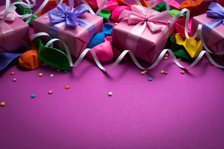 Festive background of purple material colorful balloons streamers confetti four boxes gift. Top view flat lay copy spaceの写真素材