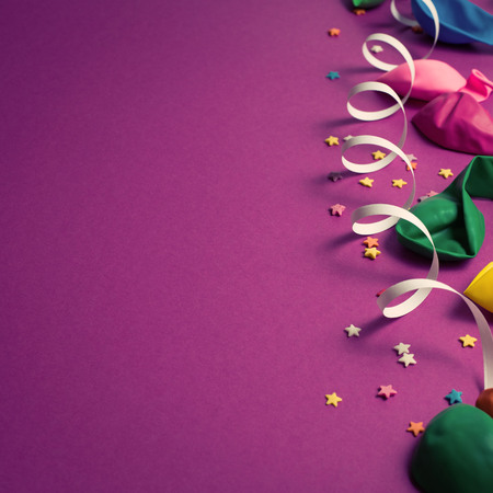 Festive background of purple material colorful balloons streamers confetti. Top view flat lay copy spaceの写真素材