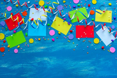 Festive bright blue background decoration for holiday colored confetti serpentine paper gifts. Top view flat lay copy spaceの写真素材