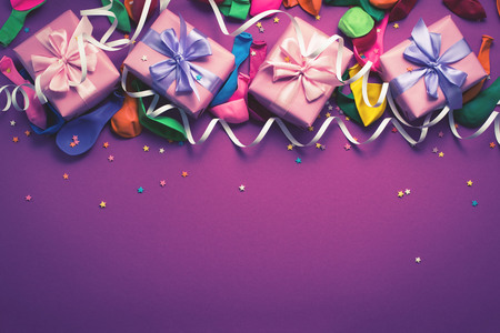 Festive background of purple material colorful balloons streamers confetti four boxes gift. Top view flat lay copy space toningの写真素材