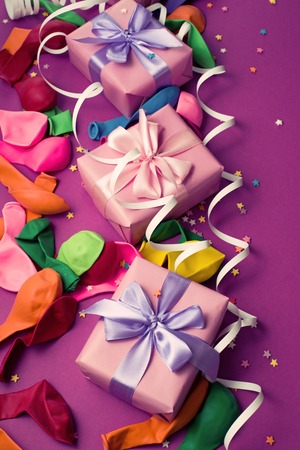 Festive background of purple material colorful balloons streamers confetti box gift. Top view flat lay copy spaceの写真素材